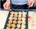  ??  ?? Takoyaki is made of a batter filled with a little piece of cooked octopus, pickled ginger and green shallots and topped with takoyaki sauce, mayonnaise, dried seaweed and dried bonito flakes.