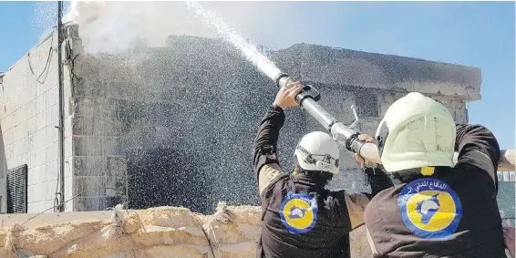  ??  ?? Civil defence workers known as the White Helmets put out a house fire on Saturday after airstrikes on Maarat al-Nuaman, a town in the Syrian province of Idlib.