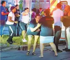  ?? AP ?? A woman breaks down as medics take wounded people away after shooting broke out at a large party in Syracuse on Saturday night.