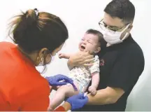  ?? PAUL HENNESSY/SOPA IMAGES/SIPA USA/ASSOCIATED PRESS ?? A nurse administer­s a dose of the Moderna coronaviru­s vaccine to Adrian Perez’s 6-month-old son in Orlando last month.