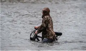  ?? Photograph: Chandan Khanna/AFP/Getty Images ?? A man walks his bicycle through a street flooded by Hurricane Sally in Pensacola, Florida, in September 2020.