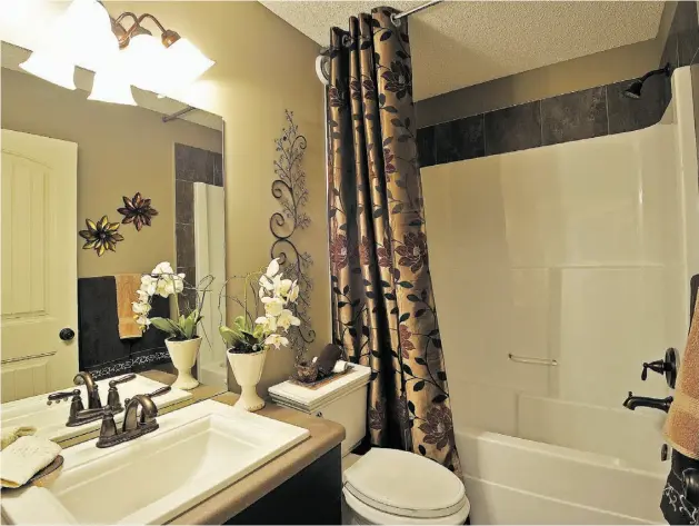  ?? LARRY WONG/ EDMONTON JOURNAL ?? The look of antique, hand-rubbed brass dominates this bathroom in a new Pacesetter show home in Beaumont.