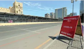  ?? | Reuters ?? A coronaviru­s warning sign is seen near the racing track of Formula One Azerbaijan Grand Prix, which was postponed due to coronaviru­s disease.