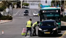  ?? Reuters ?? Israeli police check a driver at a roadblock on a main road in Jerusalem.