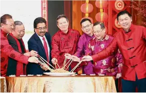 ??  ?? For prosperity: Chua (centre) with Second Finance Minister Datuk Seri Johari Abdul Ghani (third from left) tossing yee sang at a CNY dinner.