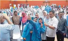  ??  ?? PELAJAR mengambil peluang berswafoto dengan Saifuddin di Dewan Kolej Mara Kulim, semalam.