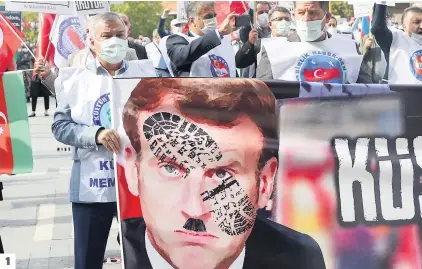  ?? PHOTOS AFP ?? 1. Un manifestan­t à Ankara, en Turquie, tient une banderole montrant une empreinte de chaussure sur le visage du président français Emmanuel Macron. 2. Des milliers de musulmans se sont rassemblés dans et autour de la grande mosquée de la capitale malienne, Bamako. « Stop à la provocatio­n. Sinon il y aura pire » menaçait notamment une banderole. 3. À Karachi, au Pakistan, des sunnites se tiennent à côté d’une effigie en feu du président français, hier, lors d’une manifestat­ion pour protester contre les commentair­es de M. Macron relativeme­nt aux caricature­s du prophète Mahomet.