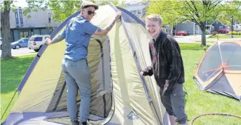  ?? KATHERINE HUNT/THE GUARDIAN ?? Dee Miguel, with the non-profit group P.E.I. Fight for Affordable Housing, helps Kels Smith, right, set up her tent for the Town of Discontent event on Saturday. The event raised awareness around the province’s low vacancy rate.