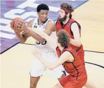  ?? AJ MAST/AP ?? Kansas’ David McCormack, left, is pressured by Eastern Washington’s Tanner Groves, right, and Jacob Groves on Saturday.