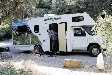  ?? GARY CORONADO Los Angeles Times/TNS ?? Daniel Miller carries dinner supplies from the rental RV his family used for a trip to Wheeler Gorge Campground in California’s Los Padres National Forest in June.