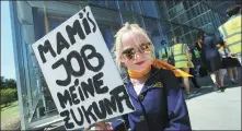  ?? RALPH ORLOWSKI / REUTERS ?? A child holds a sign in German reading “Mum’s job my future” during a protest in Frankfurt on June 24 against planned job cuts in the air carrier Lufthansa.