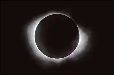  ?? Alvin A.H. Jornada/The Chronicle ?? Solar flares appear from behind the moon during Monday’s total solar eclipse as seen in Kerrville, Texas. The path of totality stretched from Texas to Kentucky, Ohio, Maine and up to Canada.