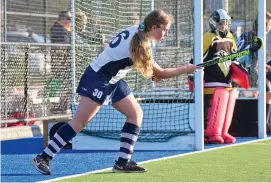  ??  ?? Emily Coster sends the ball back into play in warm conditions for hockey on Saturday.