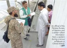  ?? — AFP ?? An official of the Pakistan Bureau of Statistics and a soldier collect informatio­n from a resident during a census at Rabwah in Chiniot district.