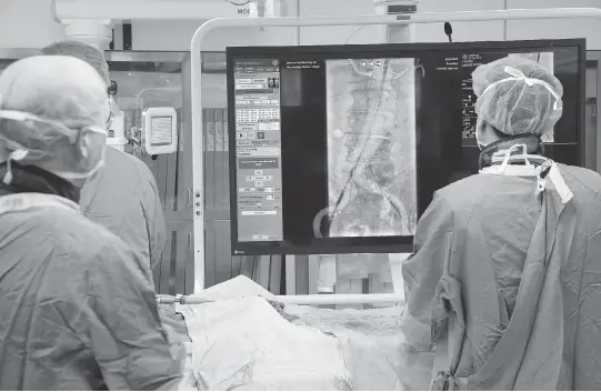  ?? WAYNE CUDDINGTON ?? In the high-tech operating room at The Ottawa Hospital, medical staff watch onscreen images of a patient during a minimally invasive surgical procedure.