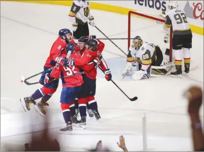  ?? The Associated Press ?? Teammates, including captain Alex Ovechkin (8), celebrate with Washington Capitals forward T.J. Oshie, who scored a goal past Vegas Golden Knights goaltender Marc-Andre Fleury during the first period of Game 4 in the NHL Stanley Cup Final on Monday in...