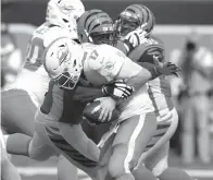  ?? Frank Victores/Associated Press ?? ■ Cincinnati Bengals defensive tackle Geno Atkins sacks Miami Dolphins quarterbac­k Ryan Tannehill (17) during the second half of an NFL football game Sunday in Cincinnati. Atkins sacked Ryan Tannehill twice and hit him three other times as he was getting rid of the ball.