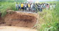  ?? FILE ?? Residents of Sunnyside and Redwood in St Catherine look at a section of the roadway that was washed away during the flooding just under two weeks ago.