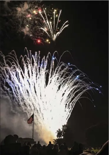  ?? The Sentinel-Record/Grace Brown ?? Fireworks provide an appropriat­e backdrop for an American flag Wednesday night during Spa Blast on the infield of Oaklawn Racing Casino Resort, above; Eric Ranum, 7, and Brooke Ranum, 5, hula hoop at The Red, White & You Picnic In The Park on Arlington Lawn on Thursday, below.