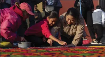  ?? MOISES CASTILLO — THE ASSOCIATED PRESS ?? Members of the Alvarez family add finishing touches to a sawdust carpet procession in Antigua, Guatemala, on Friday.