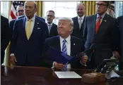  ?? THE ASSOCIATED PRESS ?? In 2017, President Donald Trump, flanked by Commerce Secretary Wilbur Ross, left, and Energy Secretary Rick Perry, announces the approval of a permit to build the Keystone XL oil pipeline. A judicial ruling Thursday has put it on hold again.