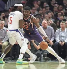  ?? CHRIS CARLSON/ AP ?? Suns center Deandre Ayton drives around Clippers forward Montrezl Harrell during the first half in Los Angeles.