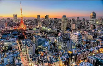  ??  ?? Tokyo’s towering skyscraper­s light up at night.