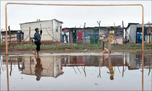  ?? PICTURE: NOKUTHULA MBATA ?? Boys in Protea Glen, Soweto, play soccer after the rain. Africa, says the writer, is the perfect example of the good soccer can do.