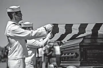  ?? CHRIS ZOELLER/AP ?? U.S. Navy sailors fold the U.S. flag over the casket with the remains of Seaman First Class Leon Arickx in Osage, Iowa.