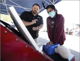  ?? JOEL ROSENBAUM — THE REPORTER ?? Tyler Johnson, an Outreach Technician with North Bay Health Care, claps along to the beat as he provides instructio­n to Makiya Mark, 11, of Fairfield as she learns about HandsOnly CPR by using a simulator Wednesday at kids' emergency medical services fair at the Solano Town Center in Fairfield.