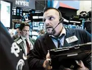  ?? RICHARD DREW/AP ?? Trader Michael Milano, right, works on the floor of the New York Stock Exchange. Equities shed 4% of value in a week.