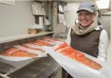  ?? J.P. MOCZULSKI/TORONTO STAR ?? Kristapson­s’ Alexis Fraser says the family-run store cold smokes, hand slices and sells more than 800 pounds of lox each week.