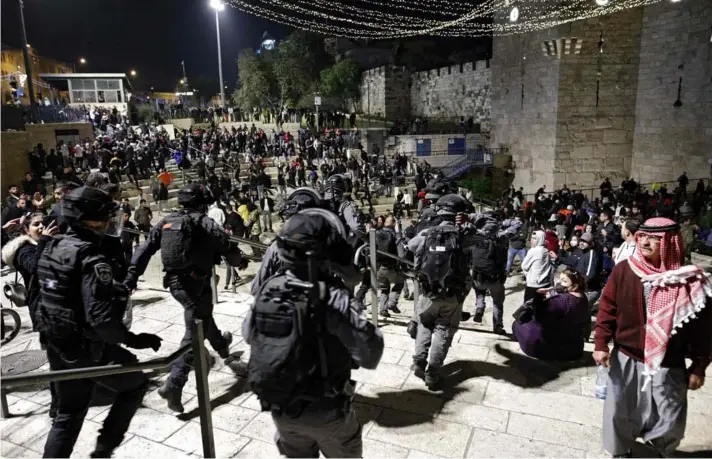  ??  ?? Fuerzas de seguridad israelíes dispersan a los manifestan­tes palestinos frente a la Puerta de Damasco, en la Ciudad Vieja de Jerusalén, el lunes.