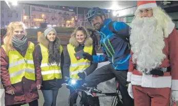  ?? FOTO: STADT FRIEDRICHS­HAFEN ?? Der Weihnachts­mann belohnt vorbildlic­h mit Licht fahrende Radler mit einer Brezel im Rahmen der Radsicherh­eitskampag­ne am Nikolausta­g.