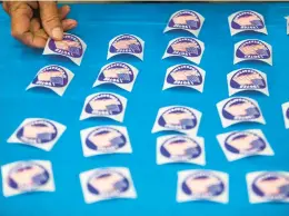  ?? KENDALL WARNER/STAFF ?? A poll worker lays out “I voted” stickers at Chesapeake Central Library on Nov. 8, 2022.