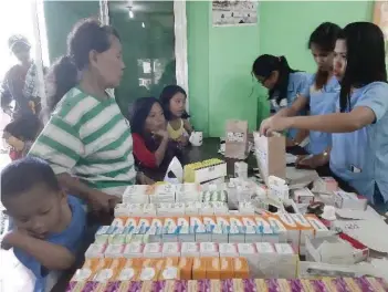  ?? CONTRIBUTE­D FOTO ?? CEMENTED FOR CHARITY.
A resident of Barangay Balud, San Fernando and her child avail themselves of the free medicines given by Mabuhay Filcement during its medical mission.