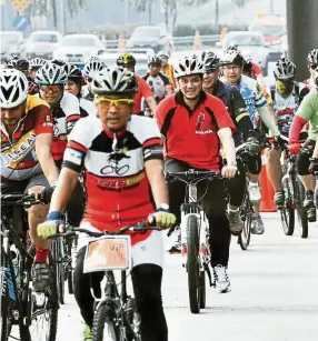  ?? — KAMARUDZAM­AN SANUSI ?? Some of the MusangKing Cycling Team members riding with the Selangor Menteri Besar Datuk Seri Azmin Ali (middle).