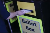  ?? JOHN LOCHER — THE ASSOCIATED PRESS FILE ?? A person places mail-in ballots at a mail-in ballot drop box at the Clark County Election Department in Las Vegas on Oct. 29, 2020.