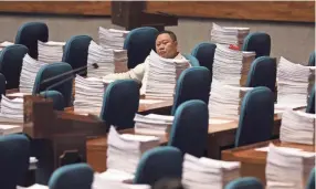 ?? AARON FAVILA, AP ?? A Philippine congressma­n waits Wednesday for the start of the Committee of the Whole to review the recent declaratio­n of martial law in Mindanao at the House of Representa­tives in Quezon city, metropolit­an Manila.