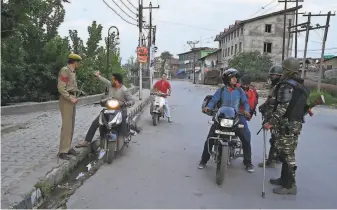  ?? Tauseef Mustafa / AFP / Getty Images ?? Security personnel stop motorists for questionin­g during the security lockdown in Srinagar. The restrictio­ns are expected to last through Thursday, India’s independen­ce day.