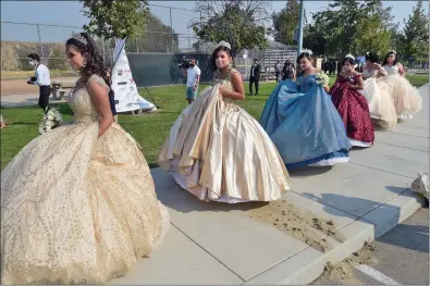  ?? Dan Watson/ The Signal ?? Six honorees, wearing sequined ball gowns and sparkling crowns, walk to the presentati­on tent during the Department of Children and Family Services’ quinceañer­a celebratio­n and car parade, held Saturday at the Castaic Sports Complex.