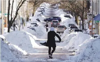  ?? AP ?? Trabajo. Mollie Lane carga una pala llena de nieve mientras limpia el frente de su casa en South Boston, un vecindario en Boston, ayer. La temperatur­a sigue baja, en menos 30 grados, y la gente ya empieza a recuperars­e.