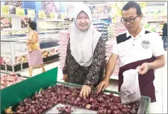  ??  ?? Zimik and husband Wahab pick shallots at the grocer’s section of the hypermarke­t.