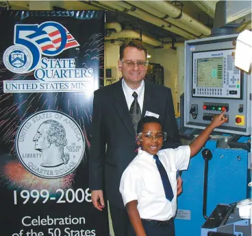  ?? (Image courtesy Patrick A. Heller.) ?? Patrick Heller and his son, Daniel, participat­e in the January 2004 Ceremonial Strike Ceremony for the Michigan state quarter, held at the Denver Mint facility. At 6 years old, Daniel may have been the youngest person to strike a United States coin.