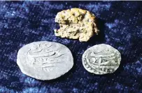  ?? PHOTOS BY STEVEN SENNE ASSOCIATED PRESS ?? RIGHT: Late 17th century silver coins with Arabic inscriptio­ns, below, and a gold nugget rest on a table in October in Warwick, R.I.