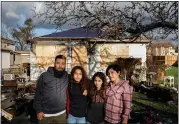  ?? RANDY VAZQUEZ — STAFF PHOTOGRAPH­ER ?? From left, Daniel Muniz, Lyric Gomez-Muniz, 14, Berlin Gomez-Muniz, 11, and Frankie Gomez stand in front of what’s left of their fire-ravaged San Jose home on Monday.