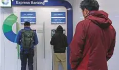  ?? Reuters ?? People use ATMs at a bank in Hong Kong. Monthly cash withdrawal­s using mainland bank cards ranged between HK$2 billion and HK$6 billion in 2017.
