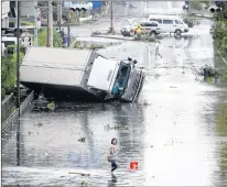  ?? AP PHOTO ?? Overturned truck is seen on flooded road following a powerful typhoon in Osaka, western Japan, Tuesday.