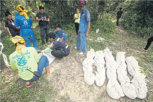  ??  ?? GRIM DISCOVERY: Six bodies — four females and two males — are exhumed for identifica­tion from an abandoned graveyard in Padang Besar of Songkhla’s Sadao district in 2015.