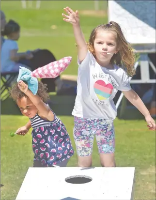  ?? Dan Watson/The Signal ?? Hazel Haynes, 2, left, and River Haness, 4, participat­e in a beanbag-toss game at the SCV Summer Art Fair held at Central park in Saugus on Saturday.